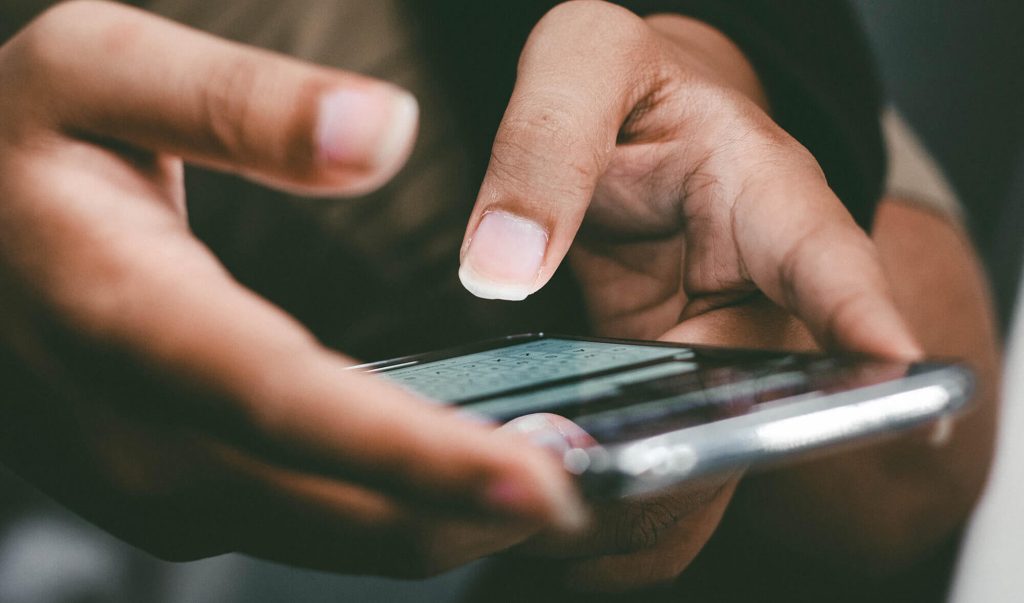 Un smartphone ținut cu ambele mâini
