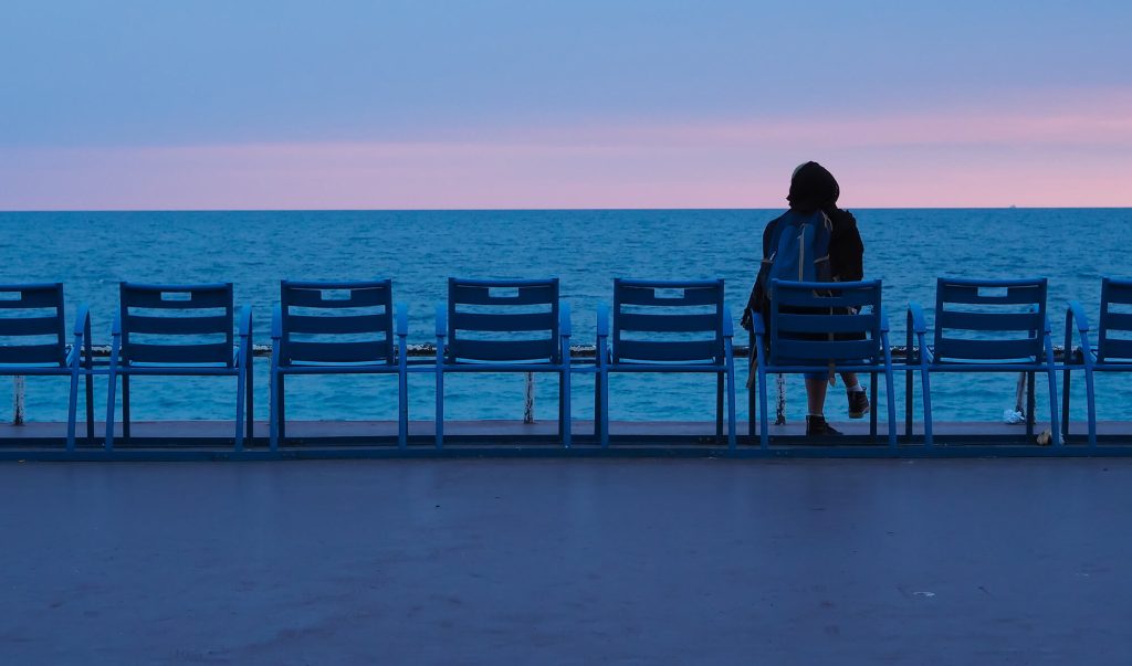 Persoană singură, pe scaun, lângă ocean