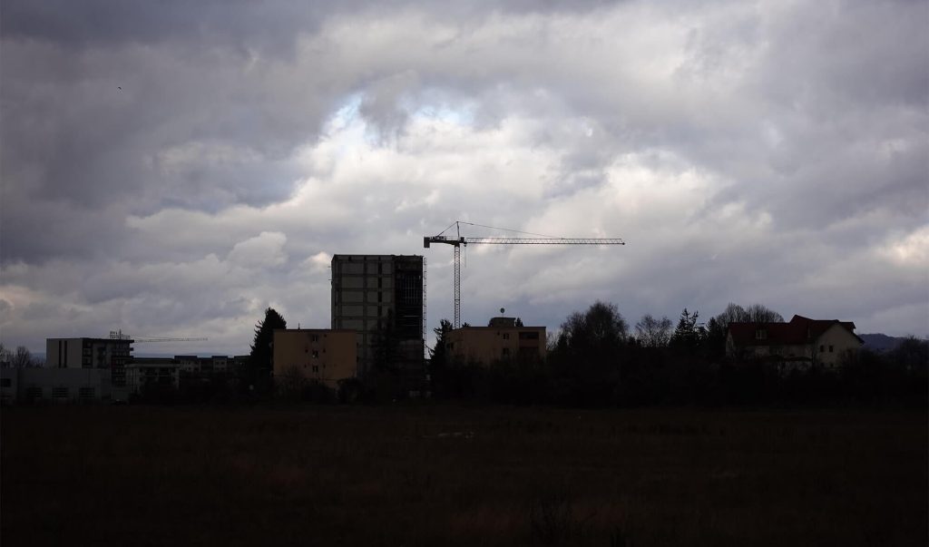 Macara într-un cartier în care se construiește, cu cer întunecat de nori